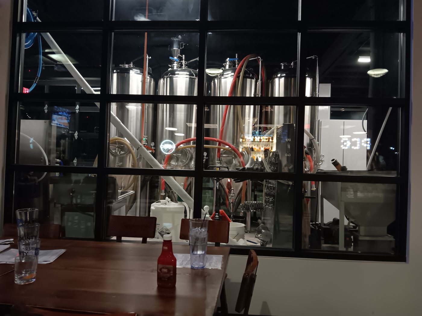 Stainless steel brewing tanks and pipes inside Parker County Brewing Company in Willow Park, Texas.