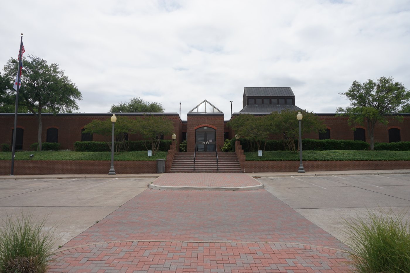 Weatherford City Hall, a low brick municipal building with a flagpole, in Weatherford, Texas.